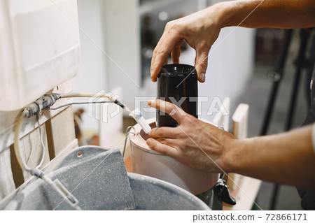 A man processes a bottle into a glass 72866171