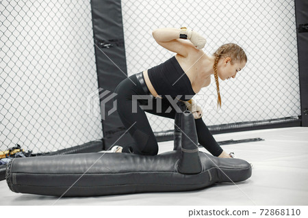 Strong woman is training with man on the self-defense course in gym. Strong woman is training with man on the self-defense course in gym. 72868110