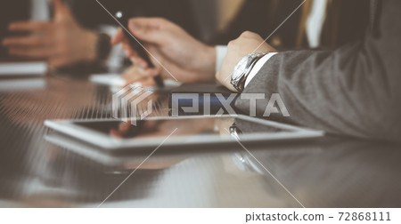 Unknown businessmen and woman sitting, working and discussing questions at meeting in modern office, close-up 72868111