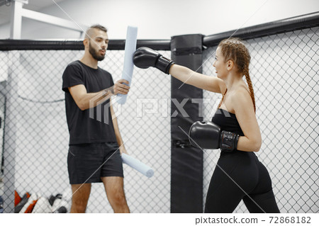 Portrait of a confident young woman in boxing gloves Portrait of a confident young woman in boxing gloves 72868182