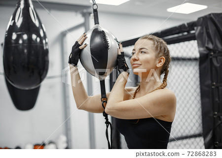 Portrait of a confident young woman in boxing gloves Portrait of a confident young woman in boxing gloves 72868283
