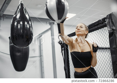 Portrait of a confident young woman in boxing gloves Portrait of a confident young woman in boxing gloves 72868286
