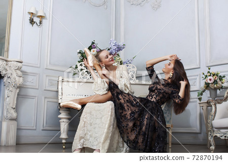 young pretty brunette ballet dancer at piano with blond woman in luxury royal interior, lifestyle rich people concept 72870194