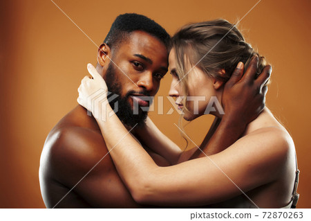 Young pretty couple diverse races together posing sensitive on brown background, lifestyle people concept 72870263