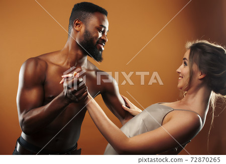 Young pretty couple diverse races together posing sensitive on brown background, lifestyle people concept 72870265