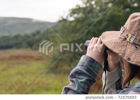 Look through binoculars 72870893