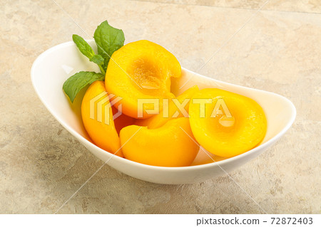 Sweet ripe canned peaches with mint 72872403