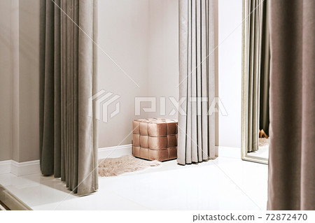 Fitting room with mirror in a dress rental service or boutique showroom Fitting room with mirror in a dress rental service or boutique showroom 72872470