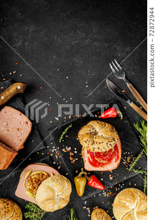 Flat lay composition of delicious hot dogs and sandwiches with different toppings on the dark background 72872944