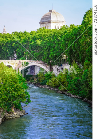 The morning of the Tiber river shining in the blue sky The Fabricius Bridge over Tiberina Island from the Ponte Palatino 72874116