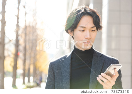 Men operating smartphones Winter city 72875348