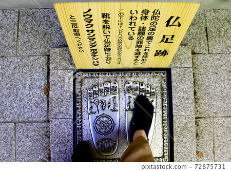 [Hiroshima] A woman who puts her foot on the footsteps of Buddha in front of Shakyamuni Buddha at Miyajima Misen Daishoin in early summer 72875731