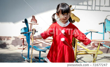 little Girl kid wearing Santa Claus uniform in the playground, Kid having fun on Christmas holiday time 72877247