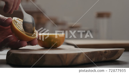 man scoop lulo fruit with a spoon on olive wood board with copy space man scoop lulo fruit with a spoon on olive wood board with copy space 72877935