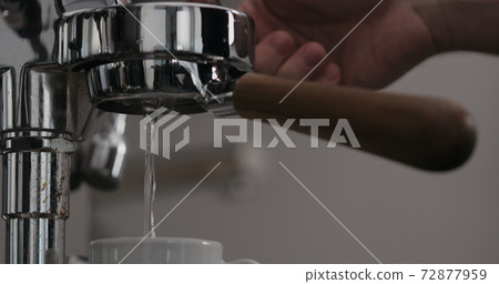 low angle shot of rinsing water from naked portafilter low angle shot of rinsing water from naked portafilter 72877959