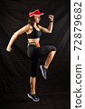 girl in red jogging uniform runs in the studio on a black background 72879682