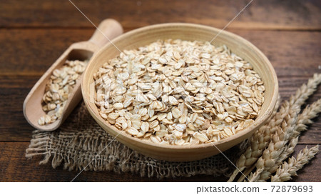 Rolled oats in a wooden bowl 72879693