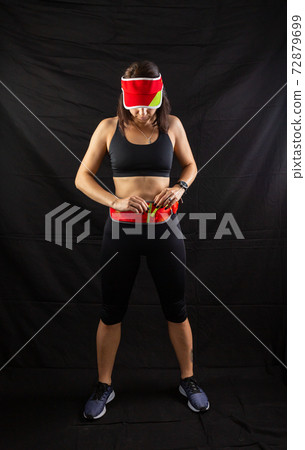 Beautiful redhead girl in jogging uniform posing in studio on black background 72879699