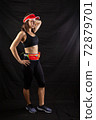 Beautiful redhead girl in jogging uniform posing in studio on black background 72879701