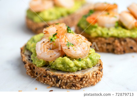 Healthy appetizer or snack avocado shrimp bruschetta 72879713