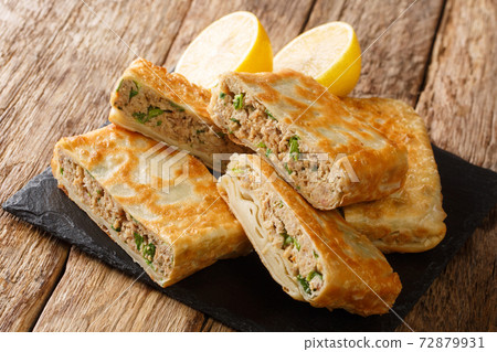 Mutabbaq also called as Murtabak is a very famous street food of middle east specially Saudi Arabia closeup in the board. Horizontal 72879931