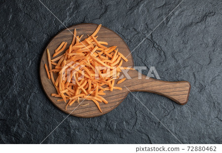 Julienne of fresh organic carrot over wooden board Julienne of fresh organic carrot over wooden board 72880462