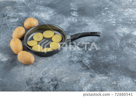 Wide angel photo of sliced and whole potatoes inside of pan Wide angel photo of sliced and whole potatoes inside of pan 72880541