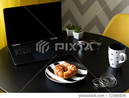 Modern black kitchen table with laptop, cup of coffee and womens accessories 72880836