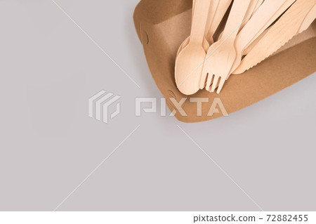 Disposable wooden cultery set made of natural bamboo - biodegradable and compostable cultery concept. Gray background with copy space, mockup image. Zero waste and environmental conservation concept 72882455