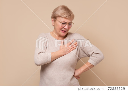 Senior woman with hands on chest having pain. Senior woman with hands on chest having pain. 72882529