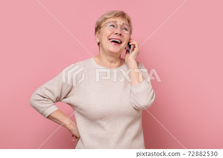 Smiling senior woman talking with mobile phone Smiling senior woman talking with mobile phone 72882530