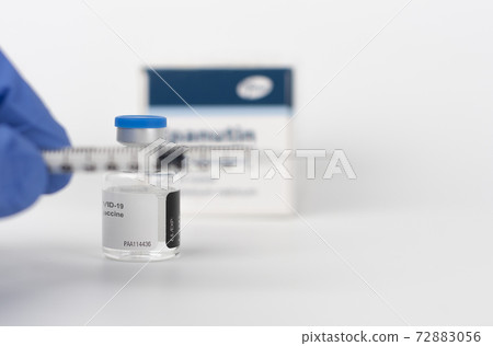 Human fingers in gloves, syringe and Covid-19 vaccine vial Human fingers in gloves, syringe and Covid-19 vaccine vial 72883056