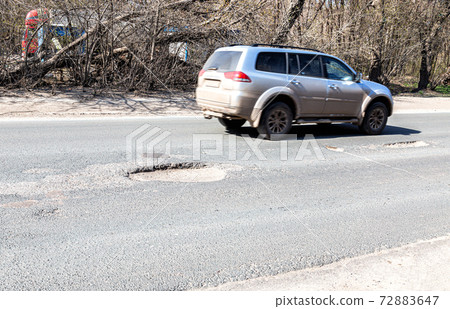 Large pothole an example of poor road maintenance 72883647