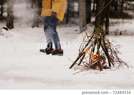 Tourists at a halt. Preparation for making a fire from spruce branches 72884516