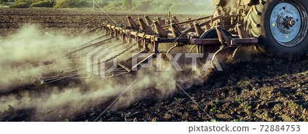 The tractor plows the land. Agricultural machinery, plow 72884753
