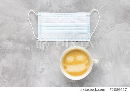 White medical face mask and cup of coffee White medical face mask and cup of coffee 72886637