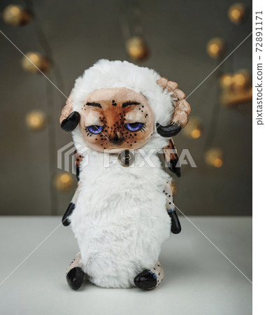 Handmade toy sad Sheep made of polymer clay on a blurred background Handmade toy sad Sheep made of polymer clay on a blurred background 72891171
