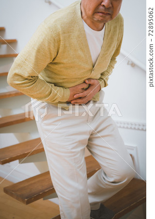 A man in his 60s who has a stomachache A man in his 60s who has a stomachache 72895062