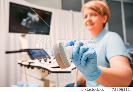 Female doctor holding ultrasound transducer. 72896311