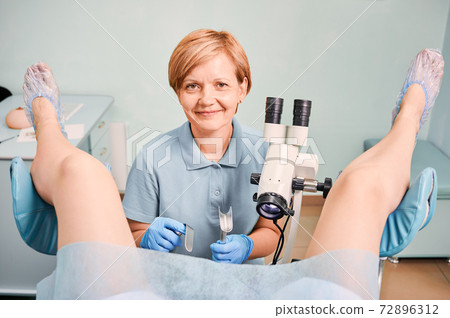 Nice gynecologist examining female patient in clinic. 72896312