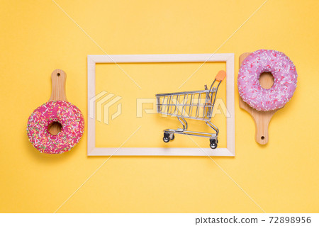 donuts with pink on a yellow background. flat lay. copyspace buying sweets 72898956