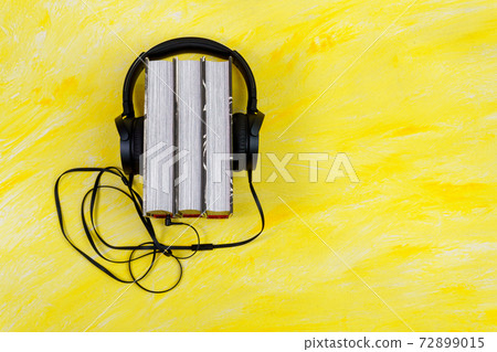 audio books concept. book and headphones on a yellow background with space for copying text 72899015