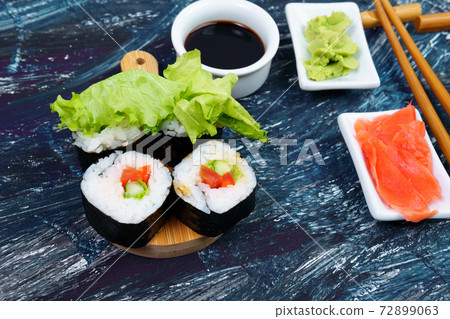 Vegan sushi rolls with avocado, cucumber salad and tomato black background. Healthy vegan food concept. Vegan sushi rolls with avocado, cucumber salad and tomato black background. Healthy vegan food concept. 72899063