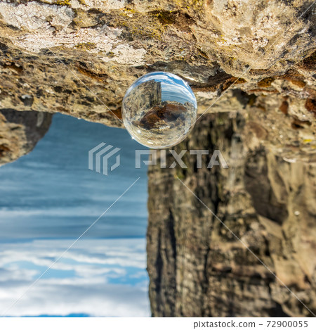 Crystal ball closeup view with high cliffs 72900055
