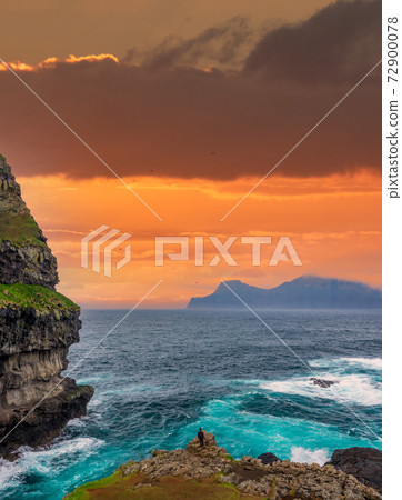 Orange sky and tourist at the end of the world 72900078