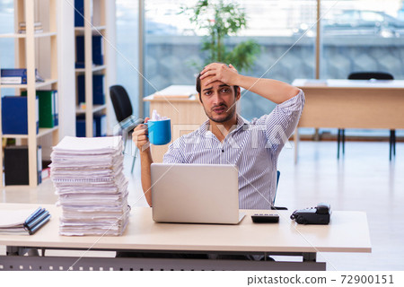 Young male employee unhappy with excessive work in the office Young male employee unhappy with excessive work in the office 72900151