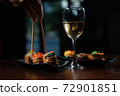 Hand, chopsticks, sushi set and white wine on dark background 72901851