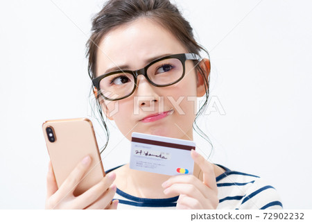 Young woman with smartphone and card 72902232