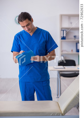 Young male doctor taking notes at the hospital Young male doctor taking notes at the hospital 72902633
