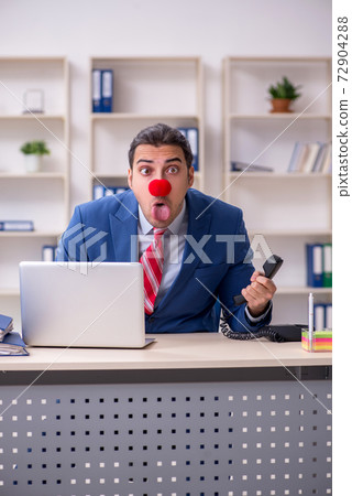 Funny employee clown working in the office 72904288
